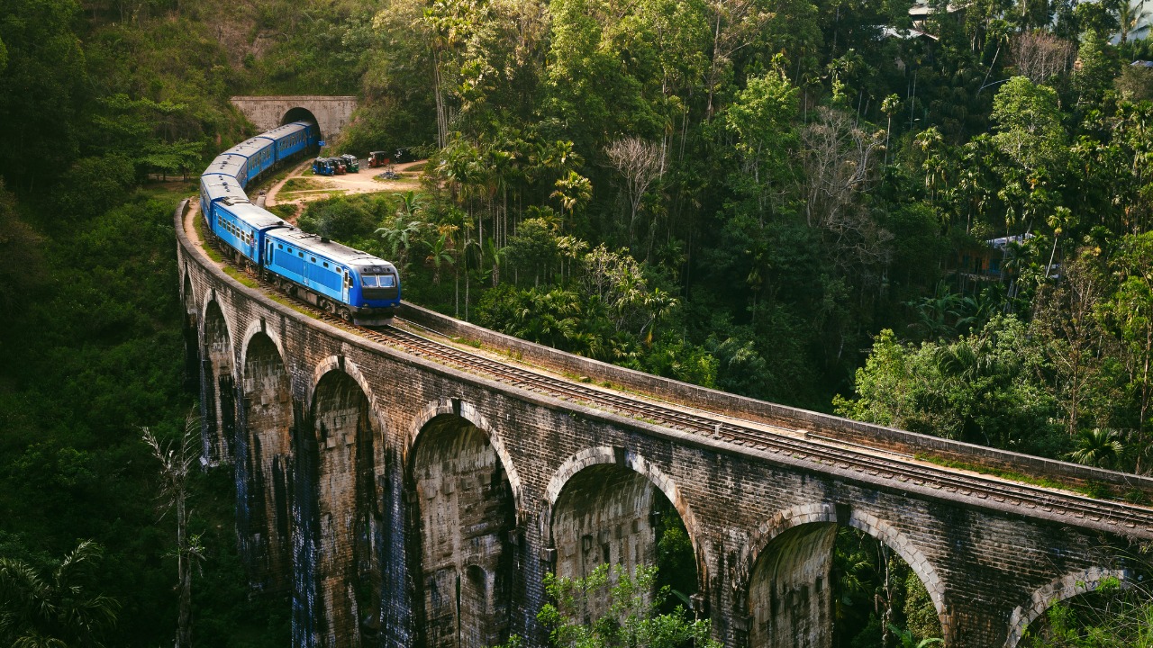 Blue train crossing the Nine Arch Bridge in Ella